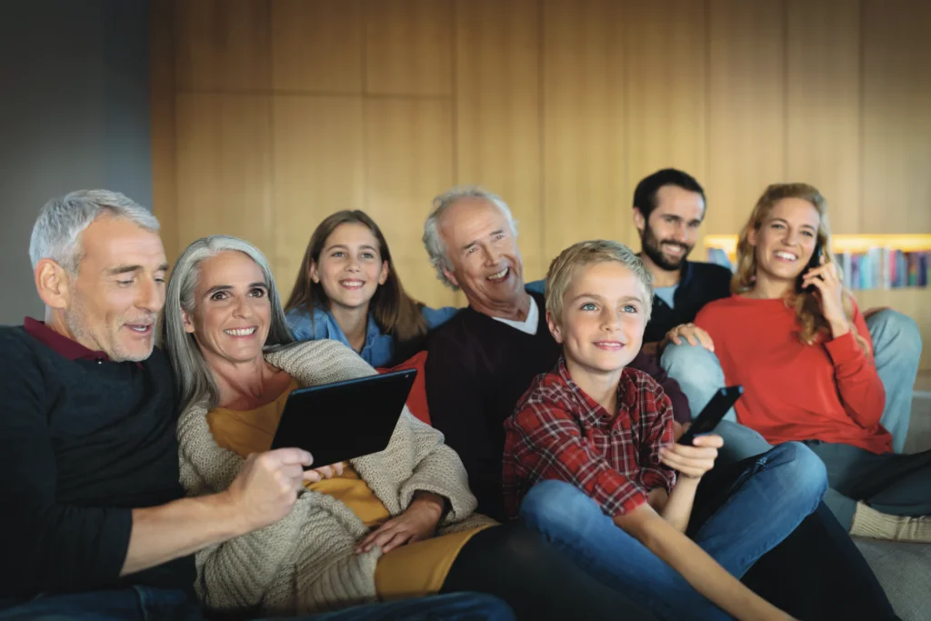 Symbolbild schnelles Internet: Familie mit Tablet und Smartphone auf dem Sofa