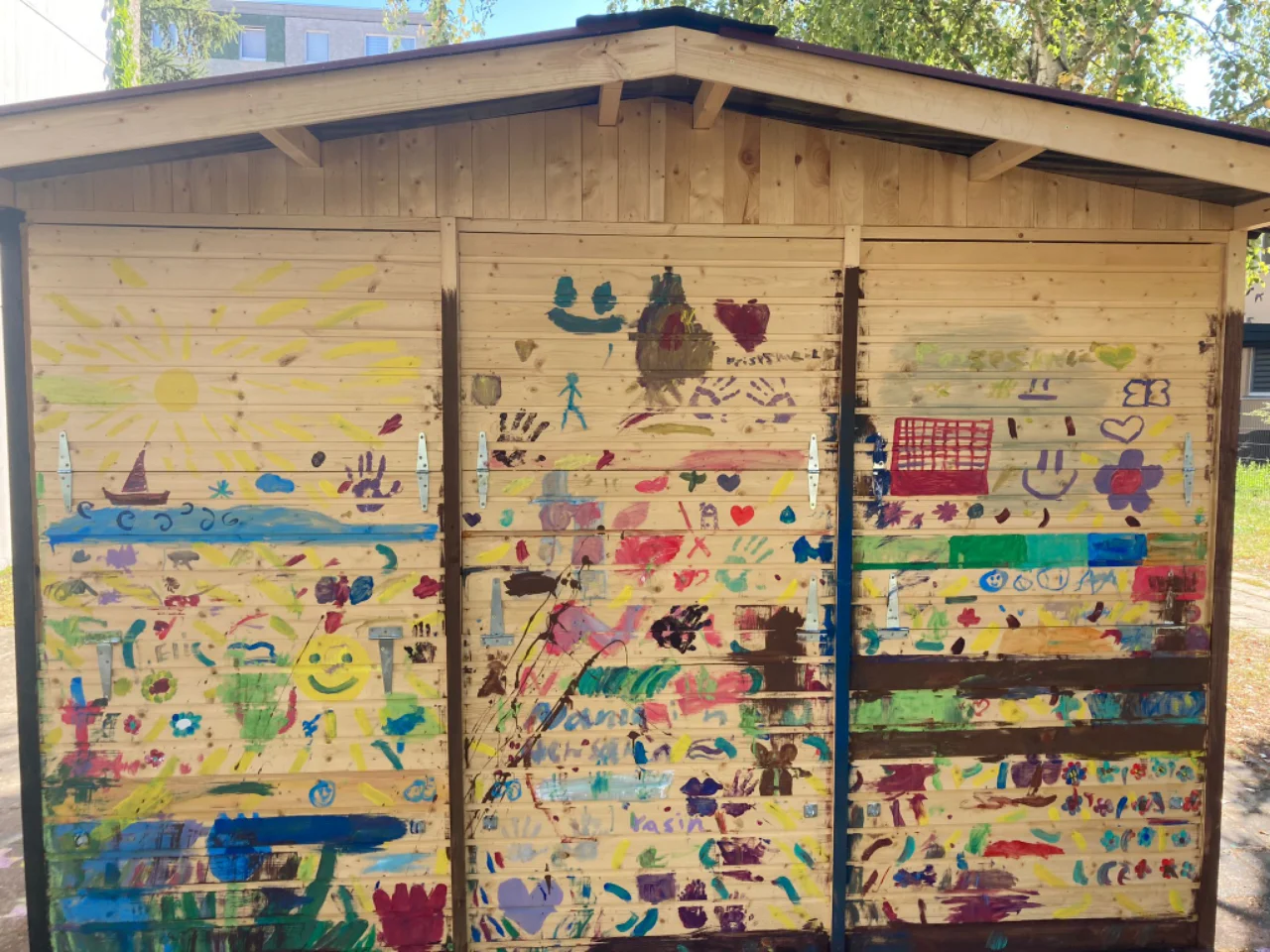 Von Kindern bunt bemaltes Gartenhaus im Wohngebiet