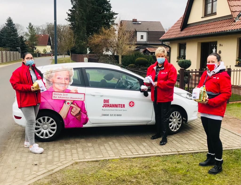 Mitarbeiterinnen der Johanniter am Hausnotruf-Fahrzeug bei einer Weihnachtsaktion